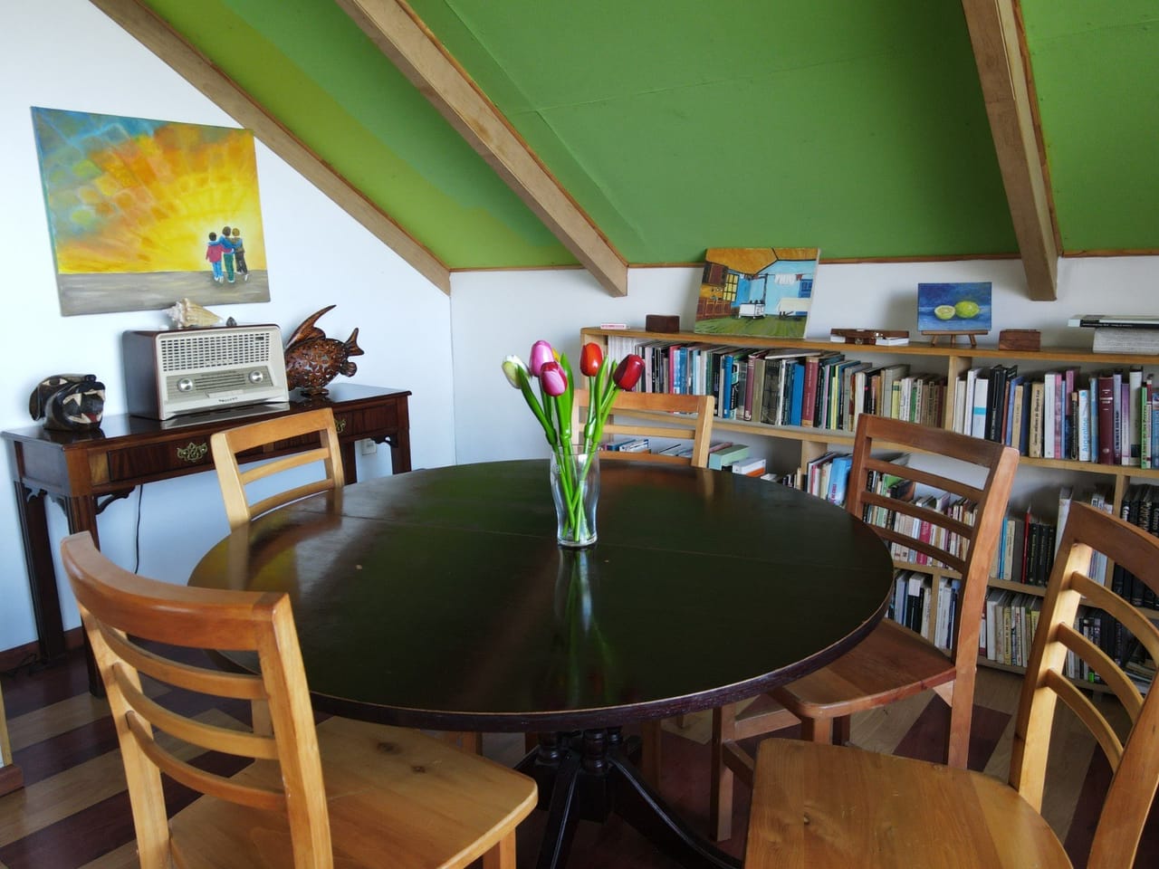 Sala de estar con mesa redonda y biblioteca del hostal