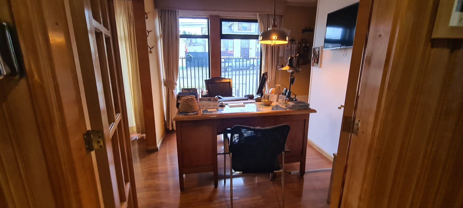 Recepción del hostal con escritorio de madera